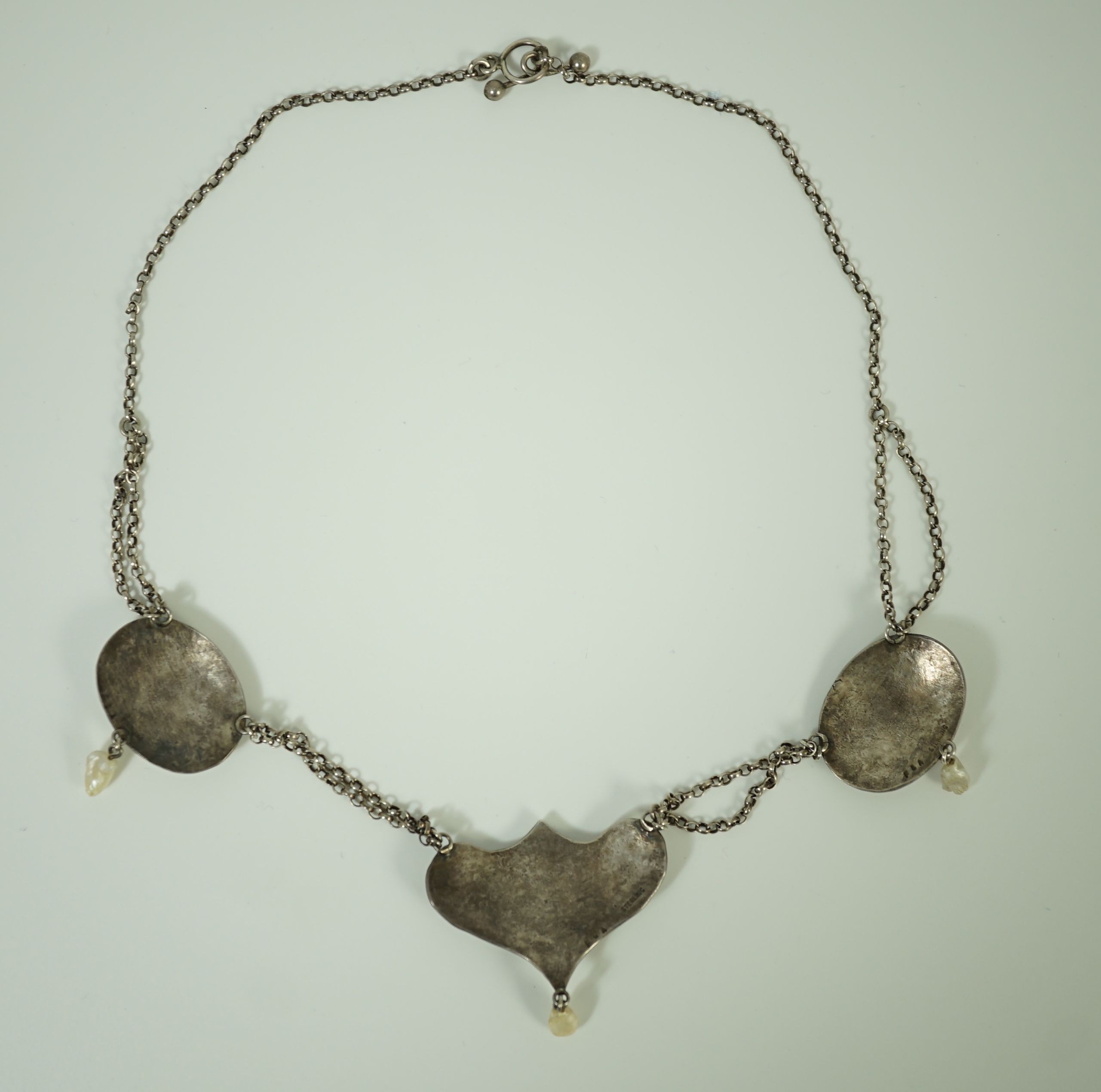 A stylish early 20th century sterling, enamel and baroque drop pearl set necklace